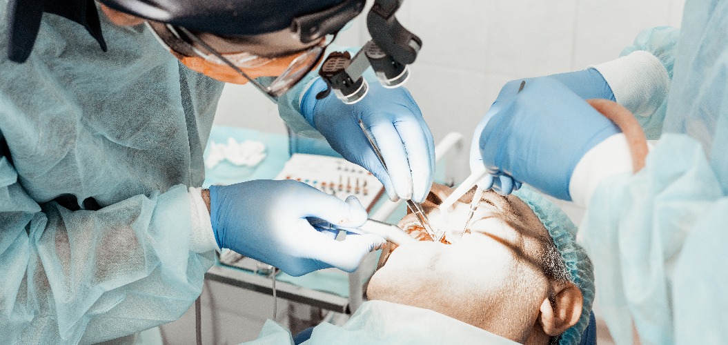 Dentists will perform an operation, implant placement. Real operation. Tooth extraction, implants. Professional uniform and equipment of a dentist. Healthcare Equipping a doctor’s workplace. Dentistry
