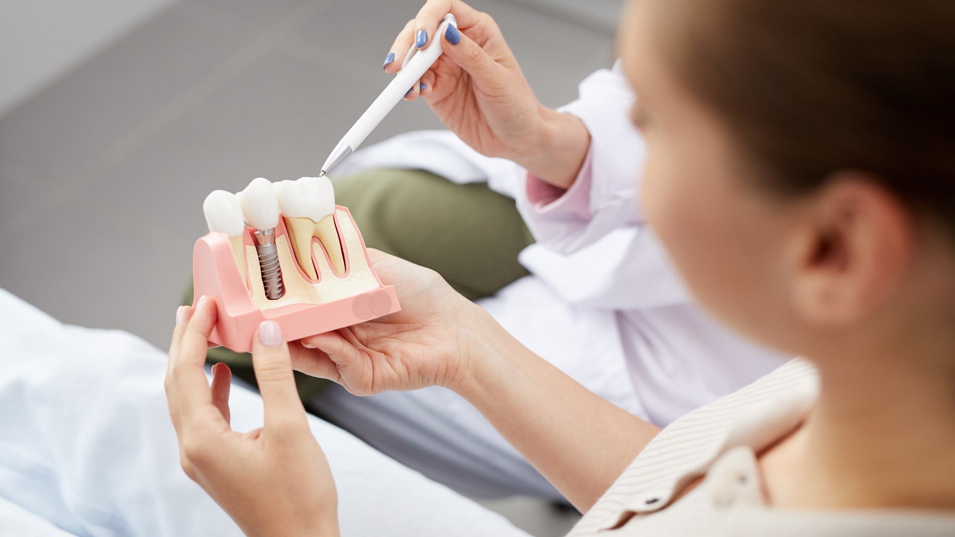 High angle view of unrecognizable young woman holding tooth model during consultation in dentists office, copy space