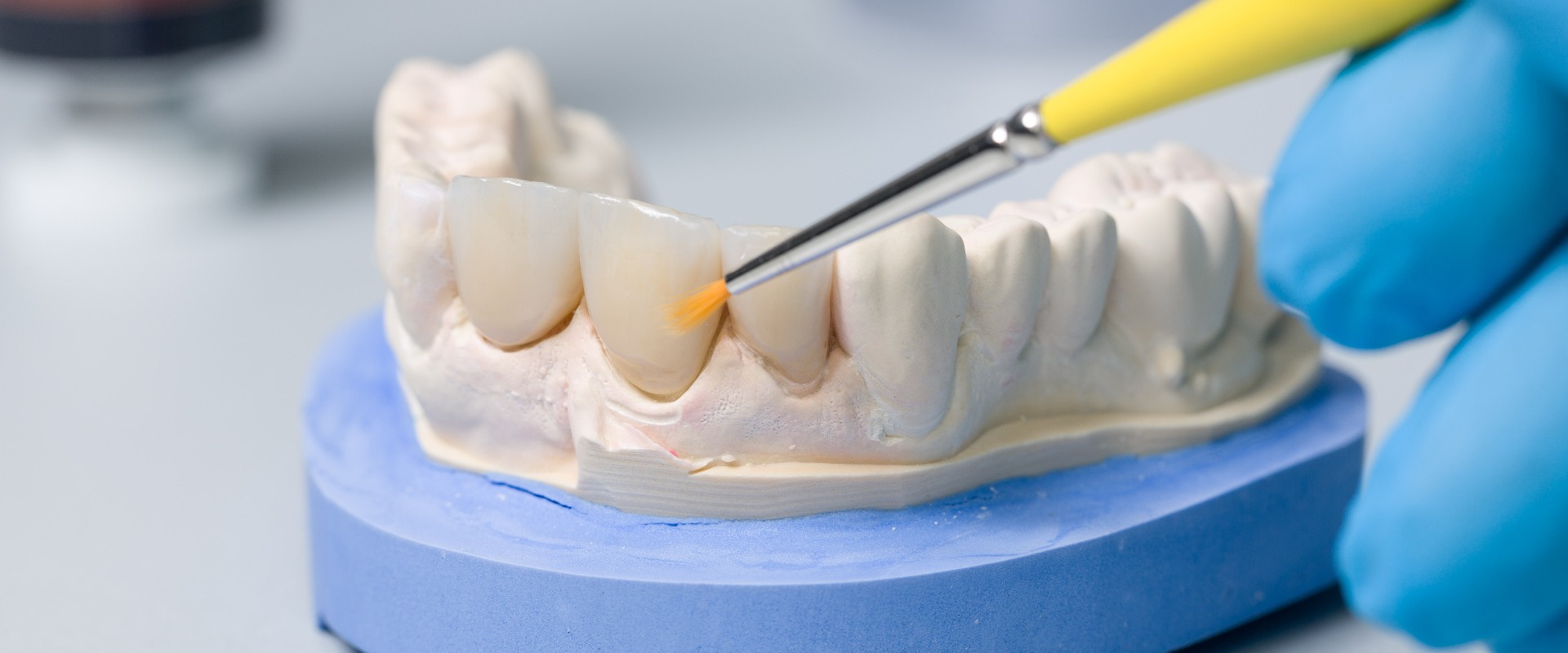 Farbliche Bearbeitung eines Zahnersatzes im Dentallabor