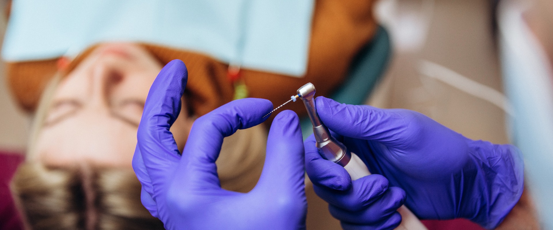 Nahaufnahme von zahnärztlichen Instrumenten: Bohrer und Nadel für Wurzelbehandlung und Pulpitis in der Hand beim Zahnarzt