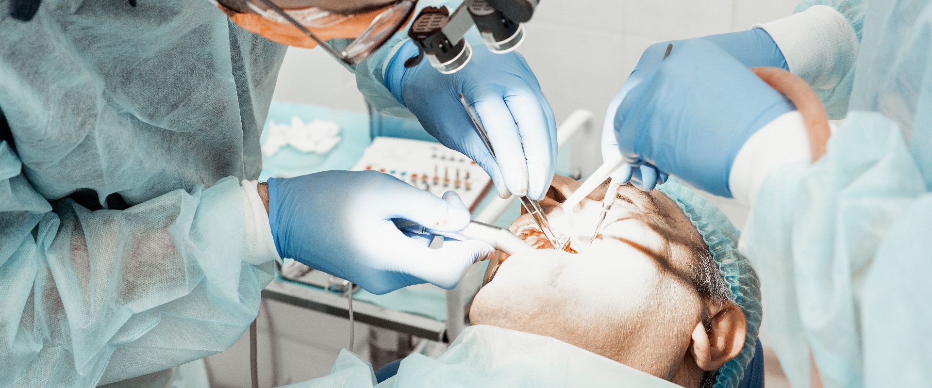 Zahnärzte führen eine Operation durch, das Einsetzen eines Implantats. Echte Operation. Zahnextraktion, Implantate. Berufskleidung und Ausrüstung eines Zahnarztes. Gesundheitswesen Ausstattung des Arbeitsplatzes eines Arztes. Zahnmedizin